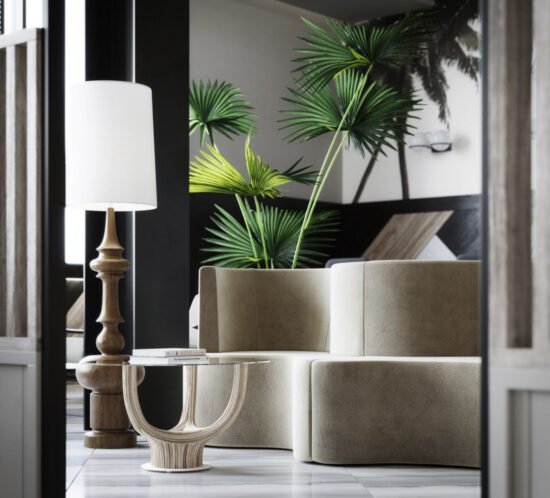 beige sofa with wood floor lamp and big palm plant